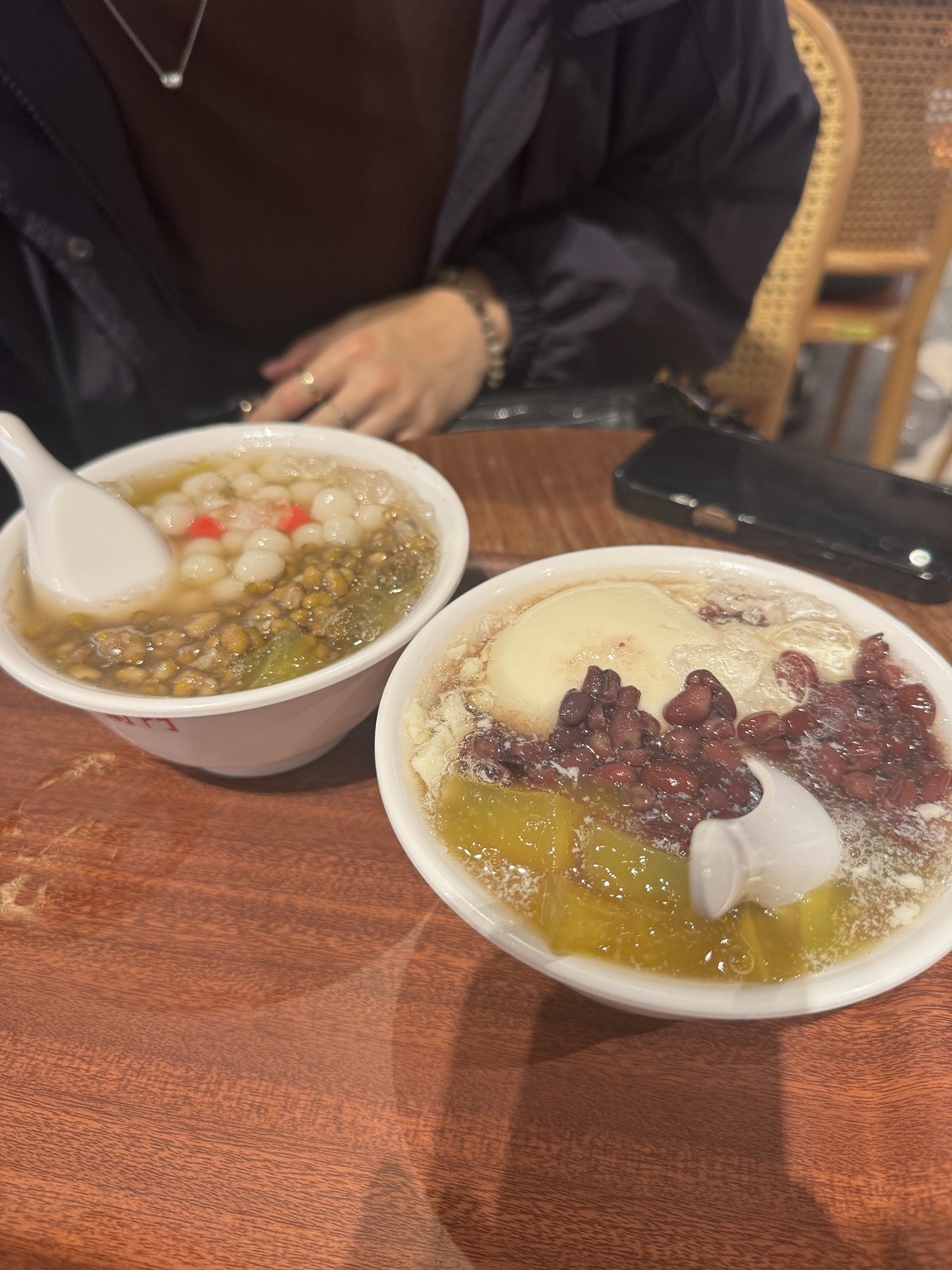 Two bowls of dessert on a wooden table at the Eslite Songyan food court.